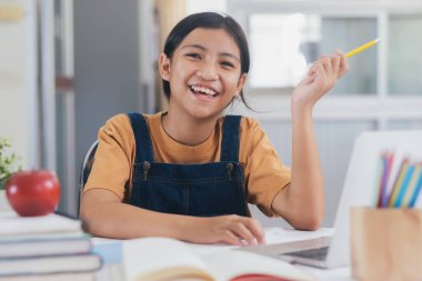 Mutlu Asyalı kız evde internetten öğreniyor. Eğitim ve e-öğrenim kavramı.