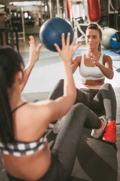 Twee meisje uit te oefenen op de sportschool — Stockfoto