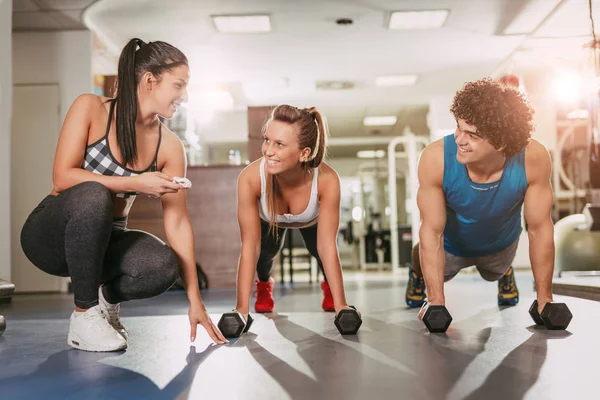 Pareja haciendo ejercicio con el instructor — Foto de Stock