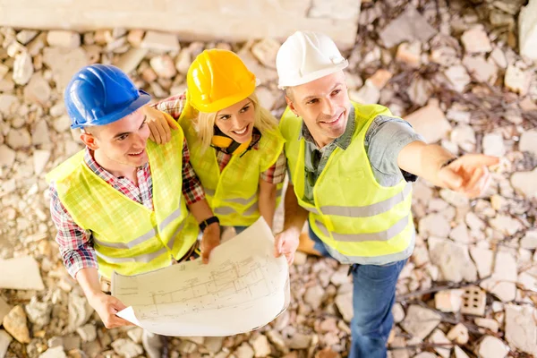 Three construction architects review plan — Stock Photo, Image