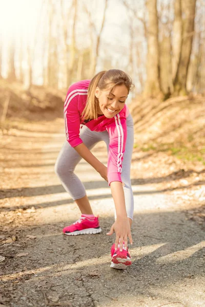 Mulher fazendo exercício de alongamento na floresta — Fotografia de Stock