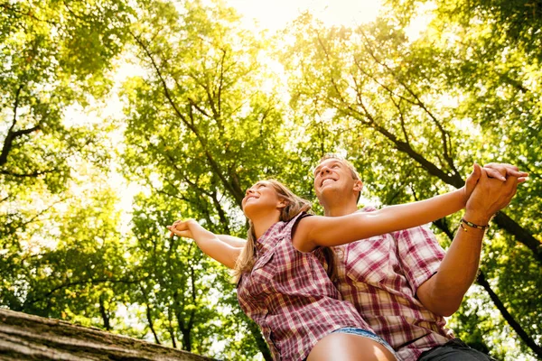 Pareja sentada en un árbol caído — Foto de Stock