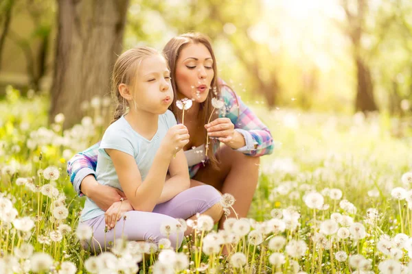 Flicka blåser maskros med mamma — Stockfoto