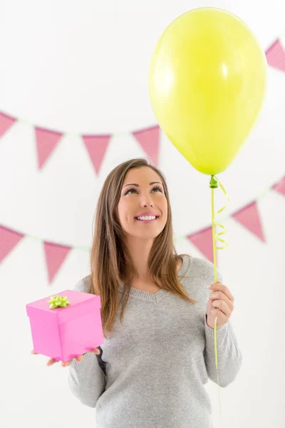 Mulher segurando presente de aniversário e balão — Fotografia de Stock