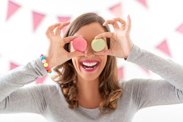 Woman holding macaroons on her eyes — Stock Photo, Image