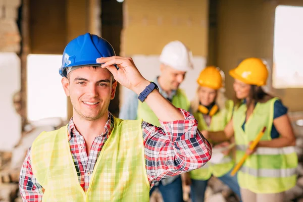 Young electrician holding helmet — Stock Photo, Image