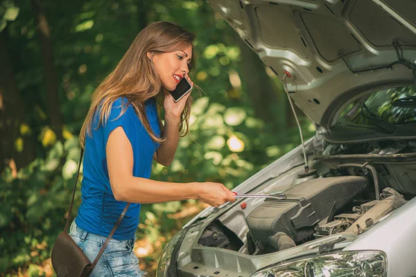 Mujer tratando de reparar su coche —  Fotos de Stock