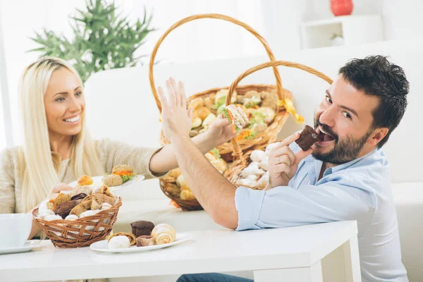 Beautiful young couple eat pastries — Stock Photo, Image