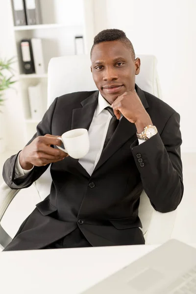 Африканский бизнесмен, сидящий в офисе — стоковое фото
