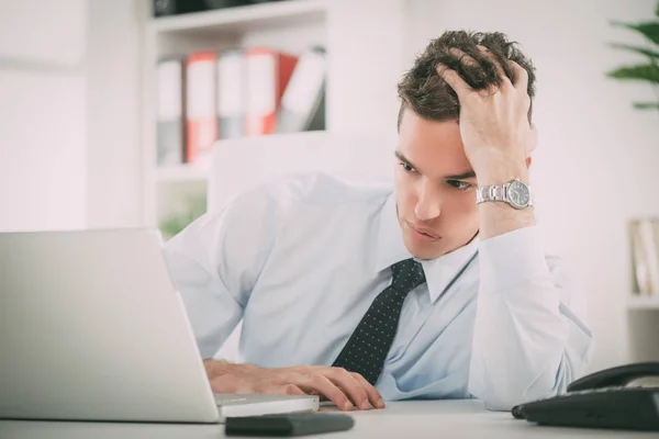 Geschäftsmann denkt nach und schaut auf Laptop — Stockfoto