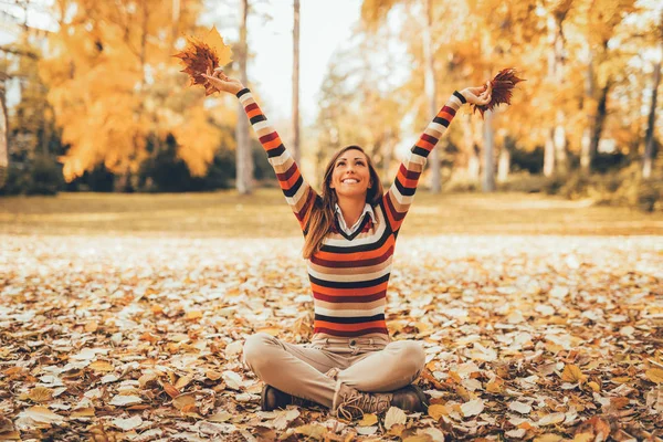 Mujer sentada en un bosque soleado — Foto de Stock