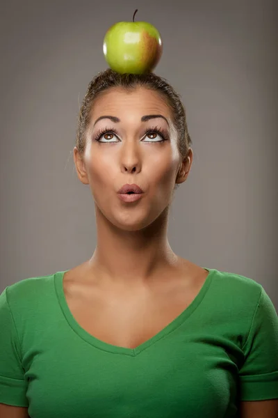 Mujer sosteniendo manzana verde en la cabeza — Foto de Stock