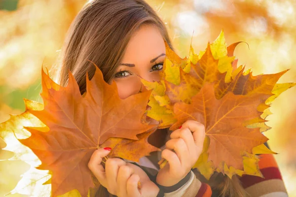 Young woman holding golden leaves — Stock Photo, Image