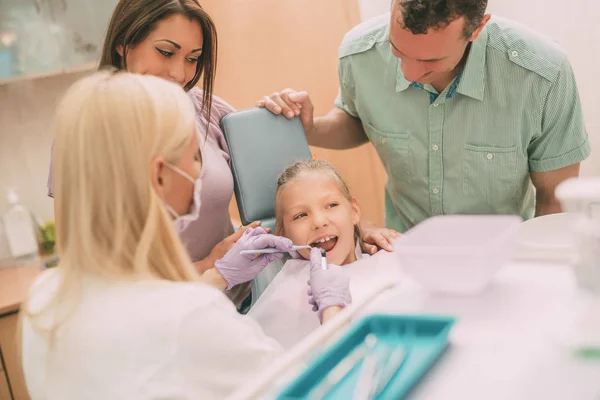 Стоматолог проверяет зубы маленькой девочки — стоковое фото