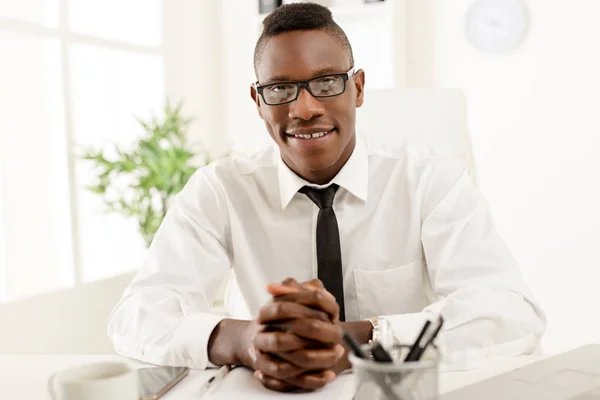 Африканский бизнесмен, сидящий в офисе — стоковое фото