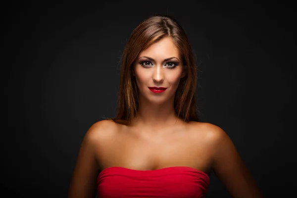 Žena v červených šatech s pěkné make-upu — Stock fotografie