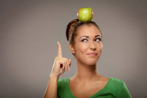 Femme tenant pomme verte sur la tête — Photo