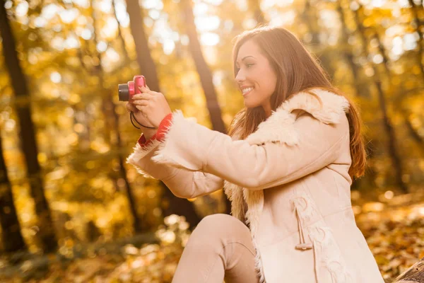 Mulher fotografando com câmera digital na floresta — Fotografia de Stock