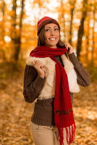 Mujer con bufanda roja y sombrero en el bosque — Foto de Stock