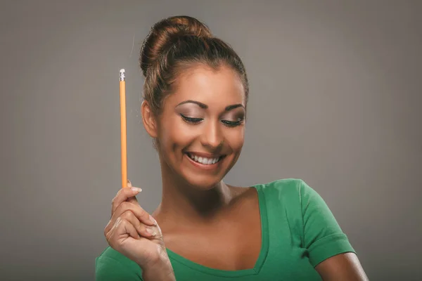 Mulher sorridente segurando lápis — Fotografia de Stock