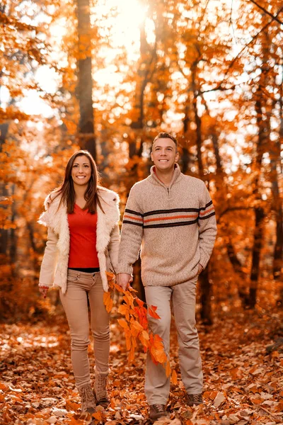 Coppia sorridente passeggiando nella foresta soleggiata — Foto Stock