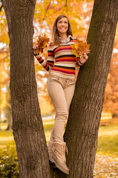 Mujer de pie entre árboles con hojas — Foto de Stock