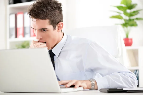 Бизнесмен сидит с ноутбуком в офисе — стоковое фото