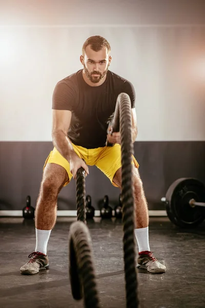 Jovem exercitando com cordas — Fotografia de Stock