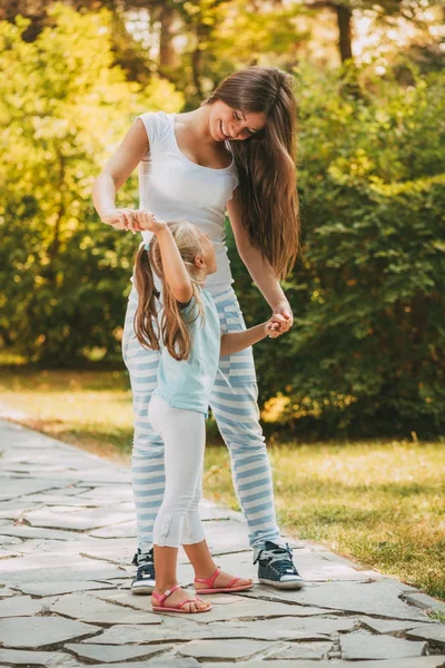 Chica y mamá divertirse al aire libre — Foto de Stock