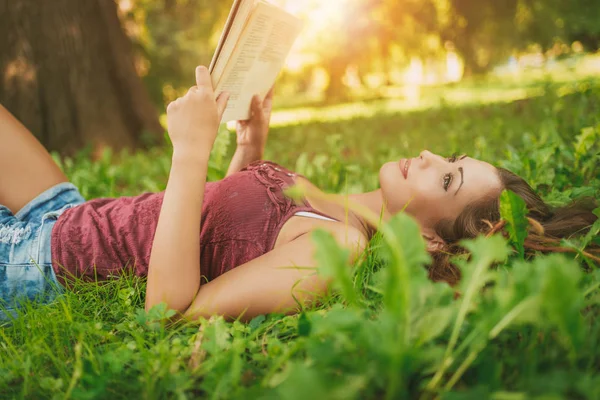 Jeune femme avec livre dans le parc — Photo