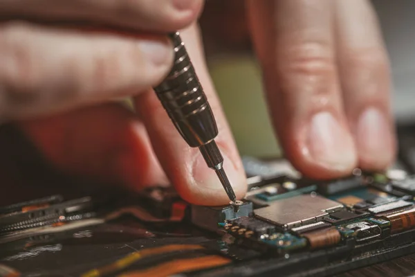 Homem reparando um telefone celular — Fotografia de Stock