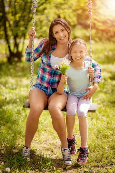 Schöne Mutter und Tochter auf Schaukel — Stockfoto