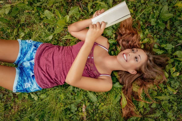 Genç kadın ile kitap Park — Stok fotoğraf