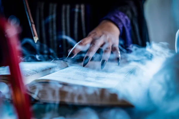 Hexenhand auf magischem Buch — Stockfoto