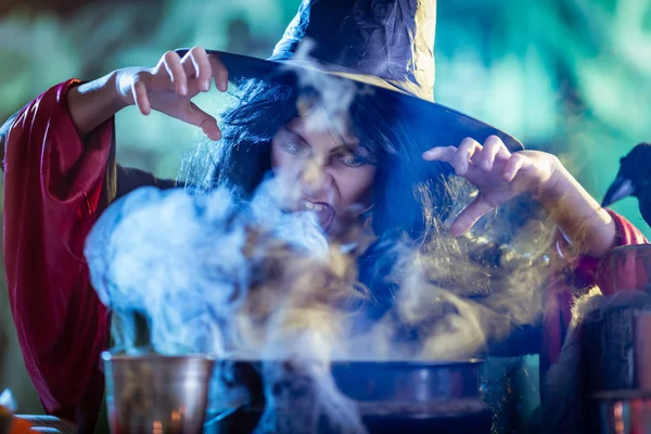 Молодая ведьма готовит с помощью магии — стоковое фото