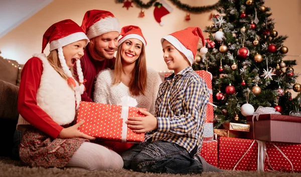 Happy family sharing gifts to each other — Stock Photo, Image