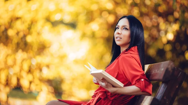 Mulher sentada no banco e segurando livro — Fotografia de Stock