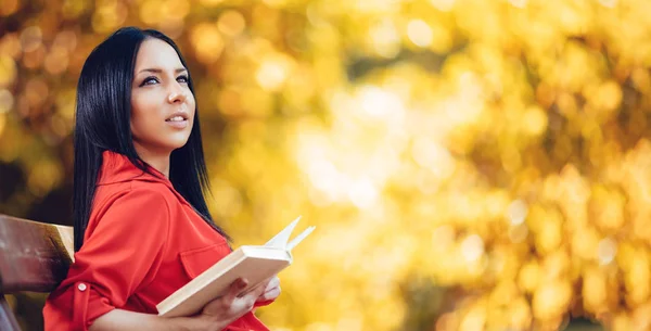 Mulher segurando livro no parque — Fotografia de Stock