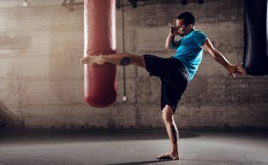 Man punching with leg boxing bag  clipart