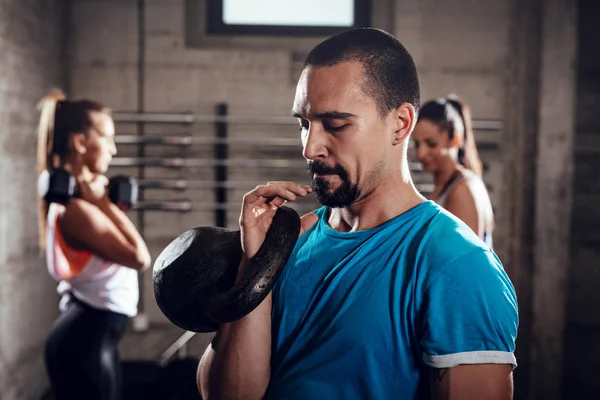 年轻的肌肉男子准备行使与壶在健身房 — 图库照片