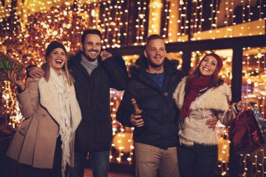 Şehrin sokak gece ve arka plan ışığı bir sürü açık yılbaşı partisinde eğleniyor genç iki çift.