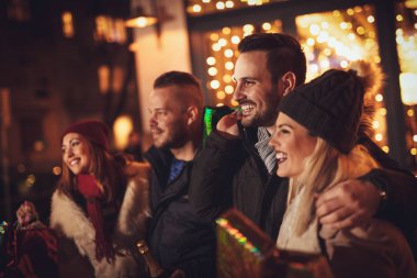 Şehrin ışıkları arka plan üzerinde bir sürü sokak yılbaşı geceleri eğlenmeye genç üç çift.