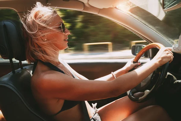 車を運転してビキニの美しい笑みを浮かべて少女 — ストック写真
