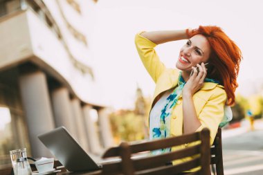 Başarılı işkadını sokak bir kafede kahve molası telefon kullanma.