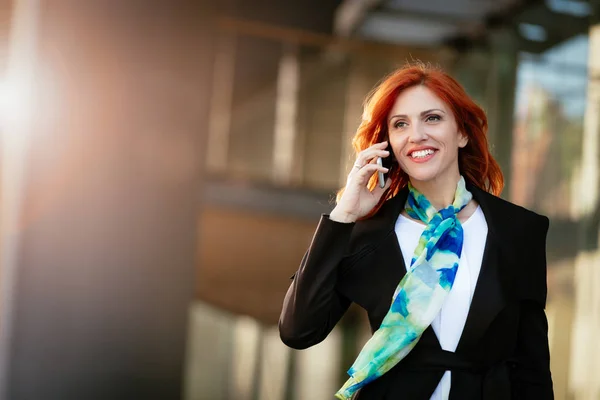 微笑成功女实业家在办公区谈论智能手机 — 图库照片
