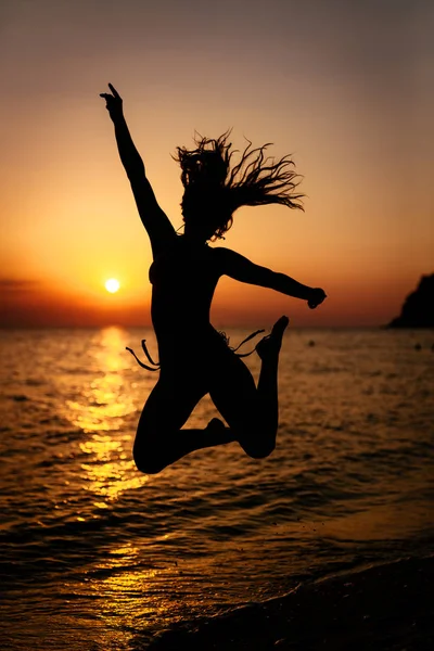 Silhouette Happy Girl Jumping Sunset Beach Stock Picture