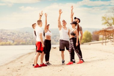 Grup mutluluk genç arkadaşlar önce egzersiz sahilde tebrik bir spor olan.