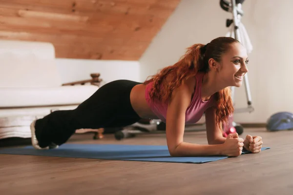 Hermosa Joven Haciendo Ejercicio Tablón Casa —  Fotos de Stock