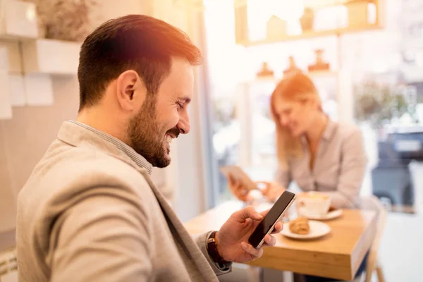 Młody Uśmiechający Się Biznesmeni Przerwę Kawiarni Człowiek Pomocą Smartfona Czytania — Zdjęcie stockowe