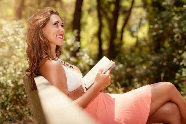 Mujer Joven Pensativa Leyendo Libro Mientras Relaja Bosque — Foto de Stock